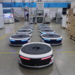A fleet of Bosch Rexroth autonomous mobile robots (AMRs) in an warehouse.